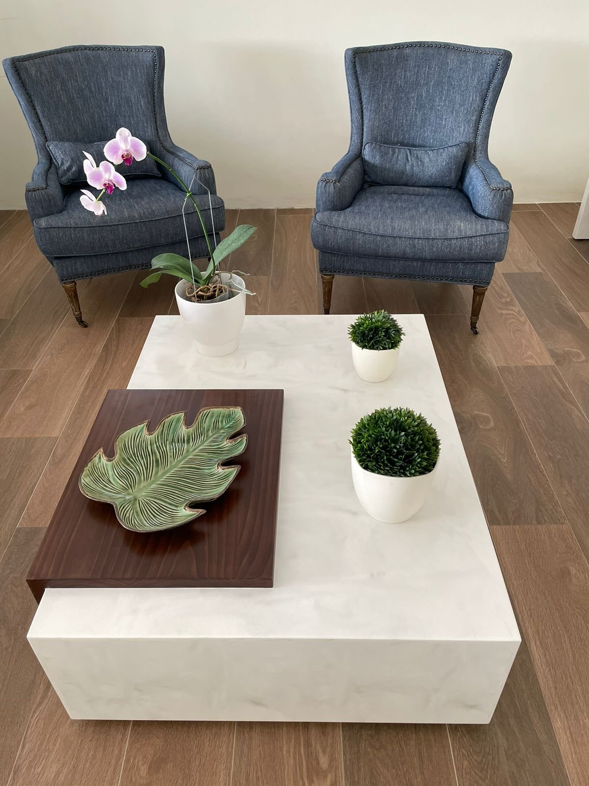 Mesa de centro en superficie sólida con sillones tapizados